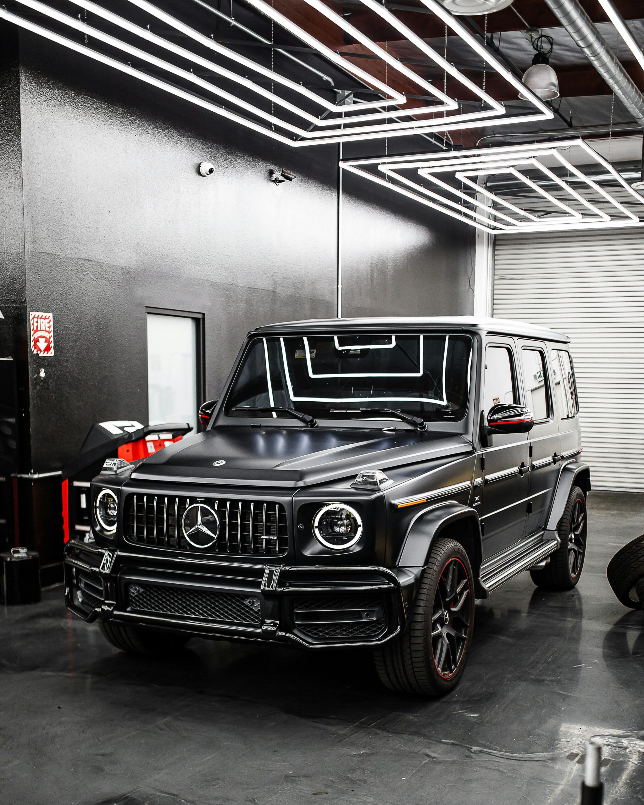Front view of a parked Mercedes-Benz SUV inside a sleek, modern automotive garage.