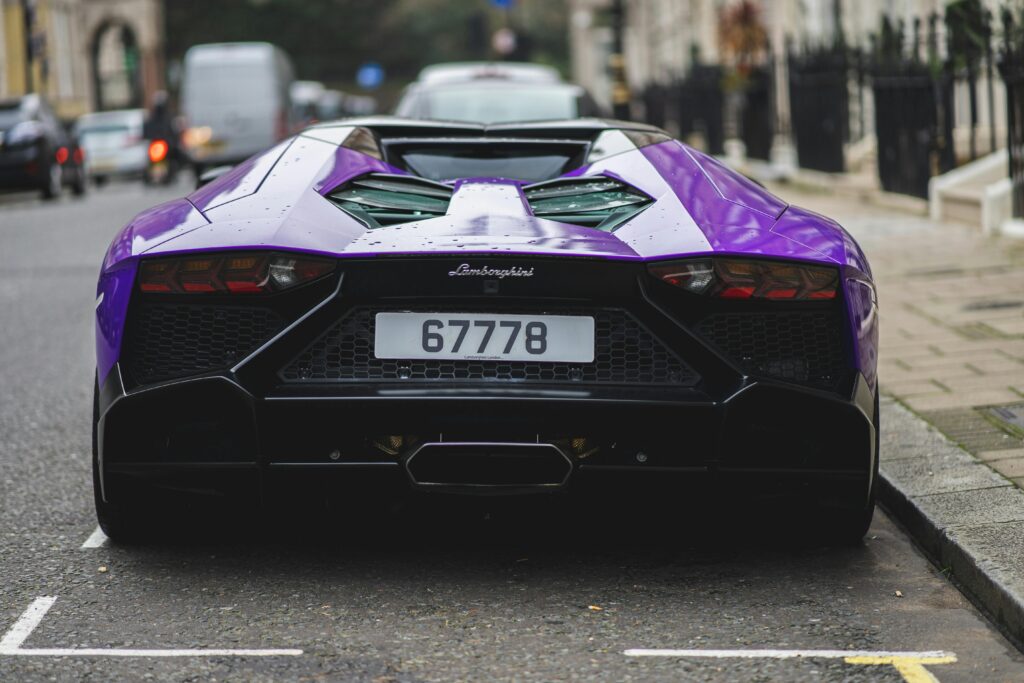 A striking purple Lamborghini Aventador parked on a London street, showcasing luxury and style.